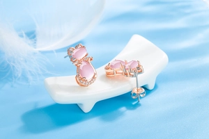 Macro detail of pink cat stud earrings with rose gold plating and sparkling zircon accents