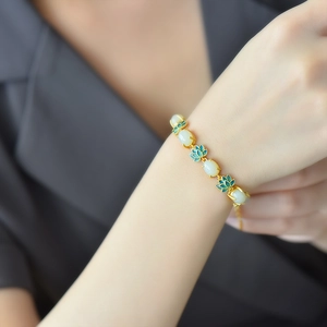 Ancient gold style bracelet with white jade stones and blue enamel lotus charms