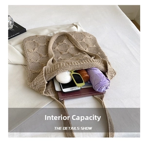 Detail view of large knit tote bag interior holding umbrella, phone, and sunglasses