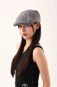 Détail de la casquette grise avec broderie ruban rose et texture en coton sergé de qualité