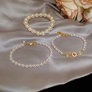 Ensemble de 3 bracelets en perles dorés 18k avec breloque œil bleu sur soie grise