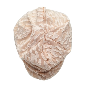 Macro shot of apricot slouchy beanie featuring white 3D floral jacquard fabric textures