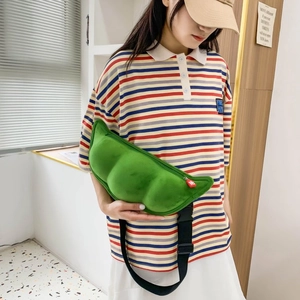 Detailed view of the green pea-pod shaped plush shoulder bag with adjustable strap