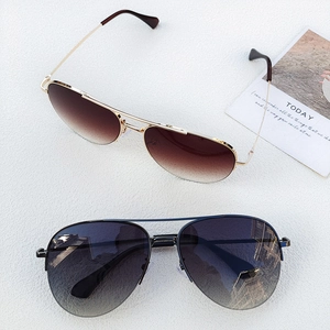 Classic aviator sunglasses with gold and black frames featuring gradient lenses in a flat lay view