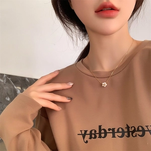 Close-up of elegant white daisy pearl pendant necklace on 18K gold-plated titanium chain