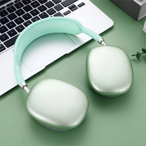 Detail view of mint green P9 Bluetooth headphones next to a silver laptop