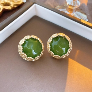 Close-up of vintage green heart flower earrings with gold textured frame detail