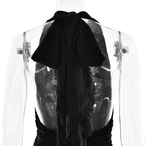 Detail of the back view of a black textured dress featuring a large bow tie design