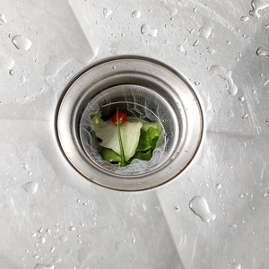 Mesh kitchen sink strainer bag over drain basket catching food scraps and debris