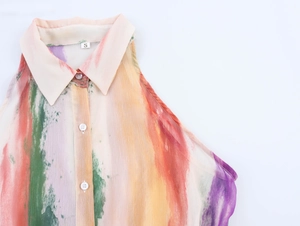 Détail d'une robe sans manches à imprimé abstrait coloré avec col chemise et boutons