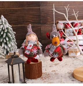 Close-up of knit Santa girl and reindeer dolls on wood background with snow