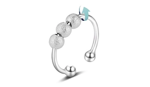 Detail of adjustable silver stress relief ring with three textured rotating beads