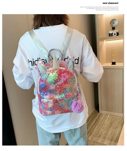 Glittery unicorn sequin backpack with star patterns and purple pom-pom on child model