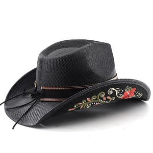Detail of floral embroidery and brown leather strap on a black cowboy hat
