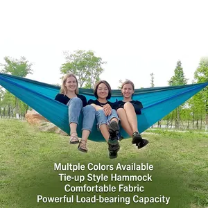 Blue and green ultra-light nylon parachute hammock supporting three adults in a park