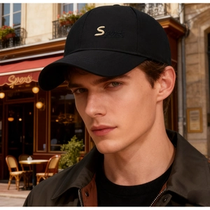 Close-up of black cotton baseball cap featuring gold S embroidery in an outdoor setting