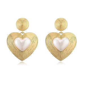 Detail of vintage heart earrings with spiral texture and center pearl inlay