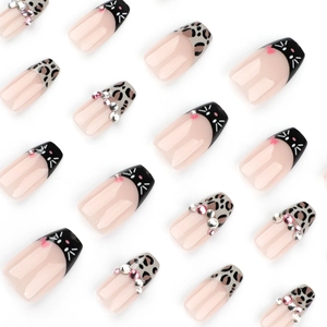 Press-on nails featuring leopard print, cat art, and sparkling rhinestones on white background