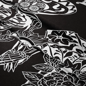Close-up of black and white skull and floral print texture on bohemian tapestry fabric