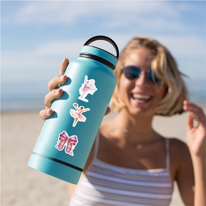Pink ballet stickers on a turquoise insulated water bottle at a sunny beach