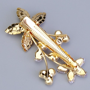 Detail view of the back clip structure of a vintage floral gold hairpin with rhinestones