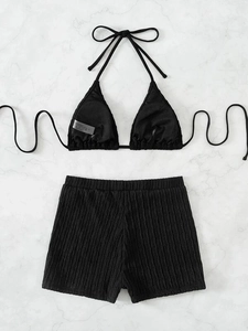 Detail showing black ribbed fabric texture of two-piece bikini set with high-waist shorts