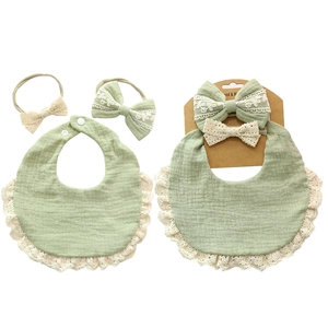 Detail view of cotton gauze baby bibs and lace headbands in light green color