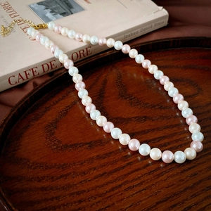 Détail d'un collier de perles bicolore vintage français avec perles blanches et roses