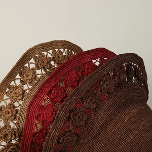 Close-up of handmade raffia sun hats featuring intricate floral hollow-out crochet details