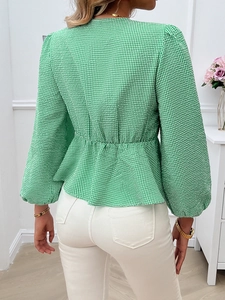 Detail of green and white plaid top showing V-neck and puff lantern sleeve style