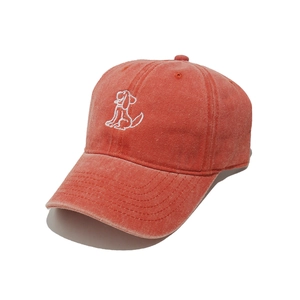 Detail of embroidered white dog motif on a washed cotton coral baseball cap