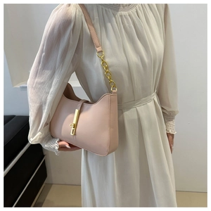 Close-up of pink underarm bag with gold piston buckle and mixed leather chain strap