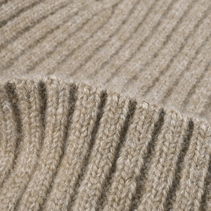 Close-up of thick ribbed camel wool knit beanie with warm fleece texture for winter
