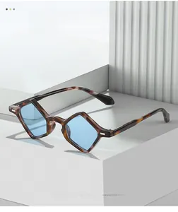 Detail of geometric tortoise shell frame sunglasses with light blue lenses on white steps