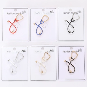 Detail view of colorful alloy stethoscope brooches in red, blue, and black finishes