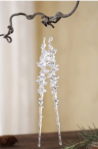 Detail of two transparent acrylic icicle ornaments hanging on branches for Christmas decor