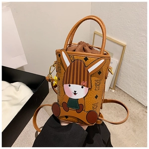 Detail of a rabbit-shaped mini bucket bag in orange-brown PU with bear pattern print