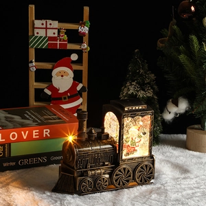 Detail of vintage Christmas train lantern with glowing LED Santa Claus snow globe scene