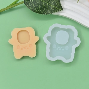 Macro shot of bear-shaped silicone mold with finished cartoon craft on pastel background