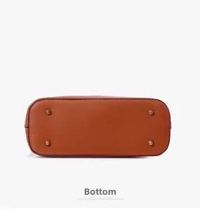 Detailed bottom view of carmel leather tote with gold protective metal feet