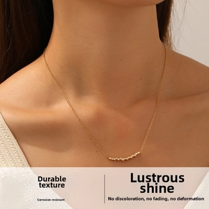 Detail of 18K gold plated necklace featuring a curved row of cubic zirconia on a model