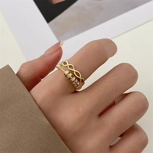 Detail of a double-layered gold fidget ring with beads and twisted design on a finger