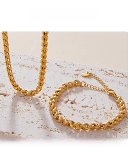 Detail of gold twisted chain bracelet with PVD plating on textured stone background