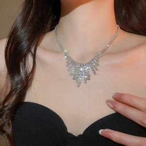 Close-up of elegant silver tassel necklace with zircons on model for luxury style