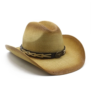 Detail of western straw cowboy hat with brown leather band and bull head metal badge