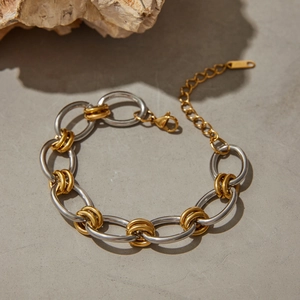 Détail du bracelet gourmette bicolore en acier inoxydable avec fermoir mousqueton sur pierre