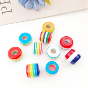 Macro detail of 14mm rainbow striped resin barrel beads for DIY bracelet making
