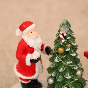 Détail du Père Noël en résine avec un sapin de Noël décoré pour la table de fête