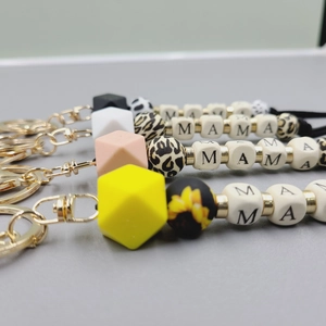 Close-up of MAMA letter silicone bead keychains with leopard and sunflower patterns
