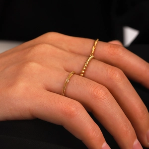 Set of two gold stainless steel rings featuring twisted rope and bead chain designs
